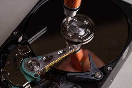 A teenager disassembles the hard drive of a computer to study its deviceの写真素材