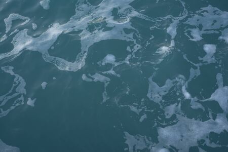 The texture of sea water and foam. Blue waves. Creative vintage background.