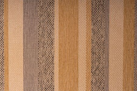 Multicolor stripes on a rough furniture fabric. Creative vintage background