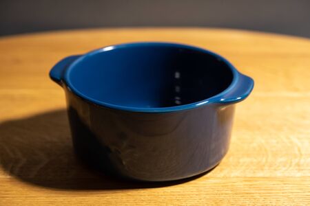 Dark blue ceramic pan on a blowing table on a gray backgroundの写真素材