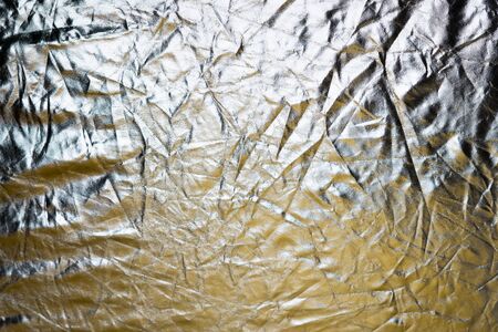 Silver and bronze foil reflector. Selective focus. Creative vintage background.の写真素材