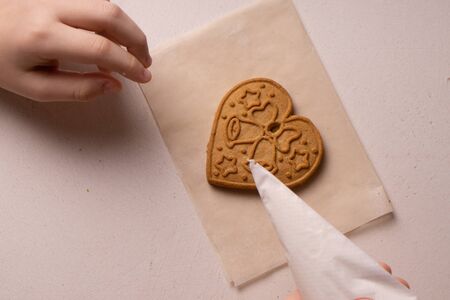 A 10-year-old boy glazes cookies with a culinary bag. Handmade. Children's creativity
