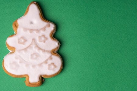 Handmade cookies in glaze in the form of Christmas toys on a green backgroundの写真素材