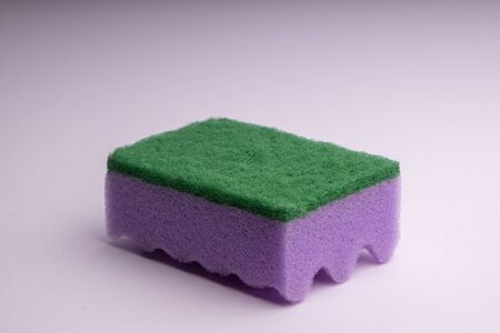 Purple foam sponge for washing dishes on a white backgroundの写真素材