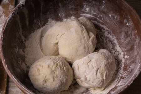 Balls of dough. Plywood cutting board, wooden flour sieve and wooden rolling pin - tools for making doughの写真素材