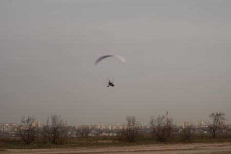 Paraglider on the lake over a sandy beach.