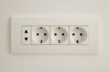 A block of white outlets consisting of three EU standard outlets with grounding and one US standard...
