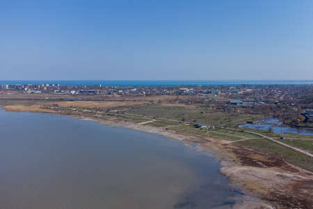 A stone spit and wooden pillars on the surface of the Kuyalnik estuary. Helicopter view