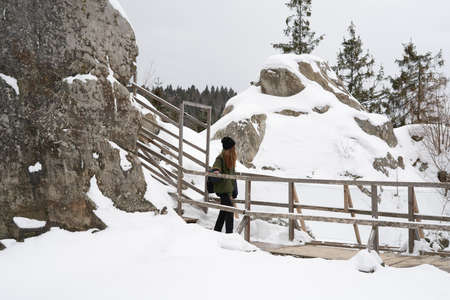 A family of tourists on a hiking trail in the mountains covered in snow on the mountainside. Selective focus. Tustan. Carpathians. Ukraineの写真素材
