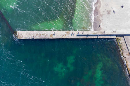 Sandy beach, concrete pier, clear sea water. Helicopter viewの写真素材