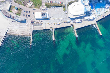 Sandy beach, concrete pier, clear sea water. Helicopter viewの写真素材