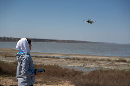 A 10-year-old boy is learning to fly a drone in a safe place