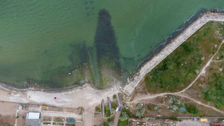 Seashore in an industrial area. Waste water discharge pipes into the sea. Aerial viewの写真素材