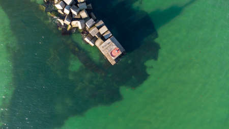 A breakwater made of white concrete cubes and a leading sign at the entrance to the port of Yuzhny. Odessa. Ukraine. Aerial viewの写真素材