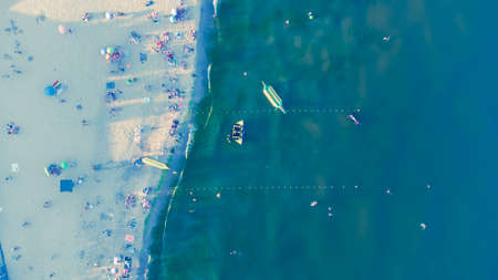 Sea sandy beach with people resting at sunrise in summer. Aerial view. Bird's-eye view of the sea coastの写真素材