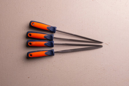 A set of locksmith's files with a blue and orange plastic handle. Joiner's hand tool