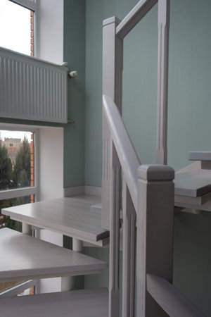 Fragment of a white wooden staircase. Steps, pillars, balusters, handrails made of ashの写真素材