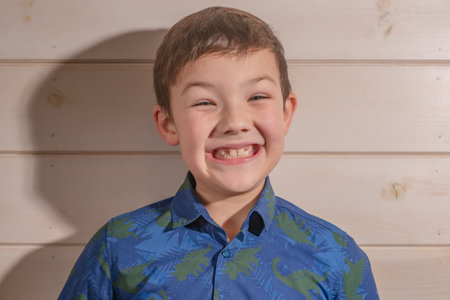 Portrait of a boy 8 years old brunette in a blue shirt. Laughsの写真素材