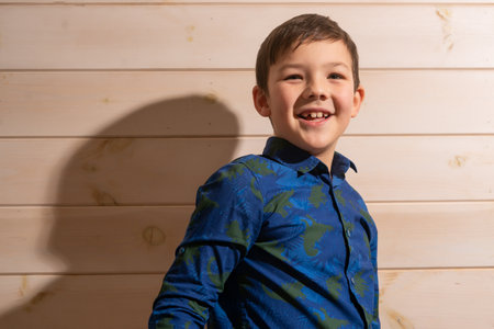 Portrait of a boy 8 years old brunette in a blue shirt. Laughsの写真素材
