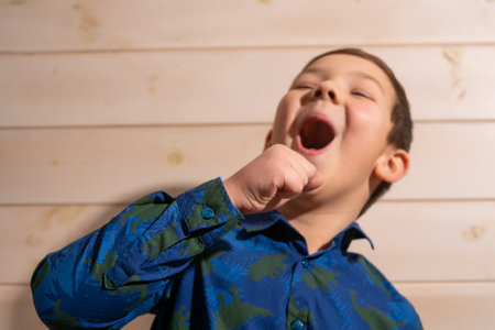 Portrait of a boy 8 years old brunette in a blue shirt. Laughsの写真素材