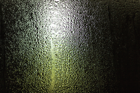 Abstract background image water drops on a window glass caused by rain on a spring day in natureの写真素材