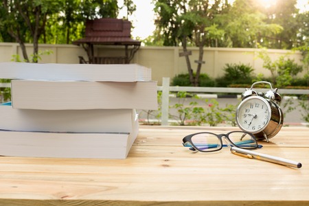 Desk on the balcony with a notepad book watches glasses and pen on the table