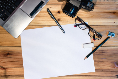 Top view of a wooden desk with office supplies placed.の写真素材