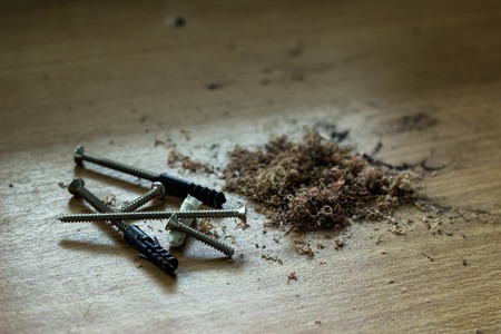 The screws are already put on the table. There is a pile of sawdust next to it.の写真素材