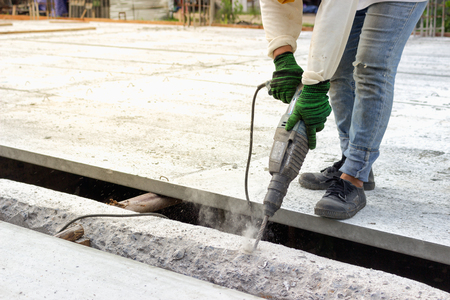Man are using punching machines to penetrate the excess cement of the building structureの写真素材