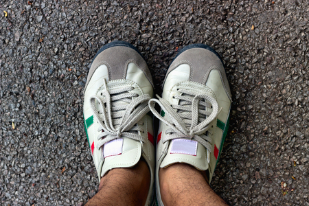 Top view of the shoes of the secondary tourism on the asphalt road.の写真素材
