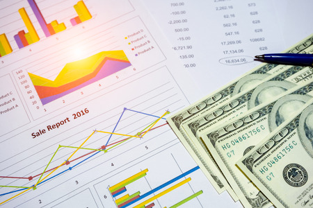 Banknote and coins depicted on economic graphs dollar currency, financial investment concepts that...