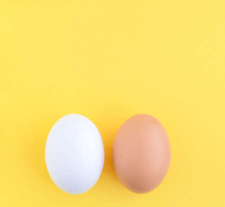Food. Two Easter eggs white and brown on a yellow background, close-up. copy space.の写真素材