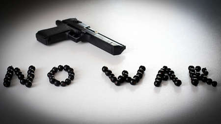 The concept is no war. Layout on a white background of a black gun and currant berriesの写真素材