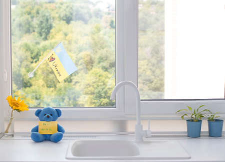 Concept. Childrens soft toy, a blue teddy bear with the inscription no war on the background of the...