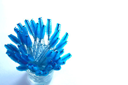 Professional blue cosmetic brushes stand in a glass on a white background. copy space.の写真素材
