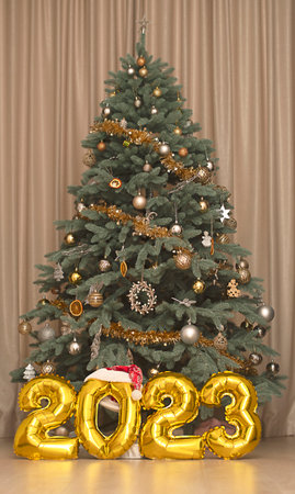 christmas concept. home interior. Large golden numbers 2023 on the background of a decorated...