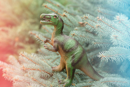 Toy green dinosaur in the jungle. Green background.の写真素材