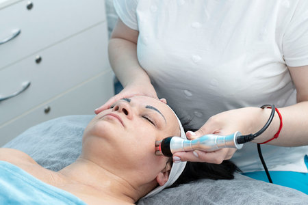 Health. Cosmetology. An aged woman lies on a couch in a beauty salon for a facelift procedure.