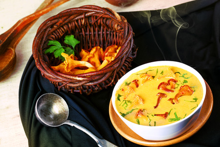 chanterelle mushrooms in a basket and hot soup with steamの写真素材