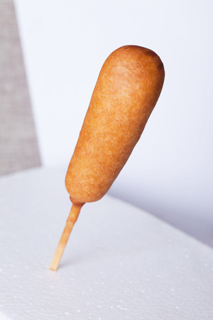 corndog sausage on a stick on a white backgroundの写真素材