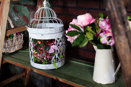 delightful iron pitcher in the style of Provence with Silk flowers peonies, birdcageの写真素材