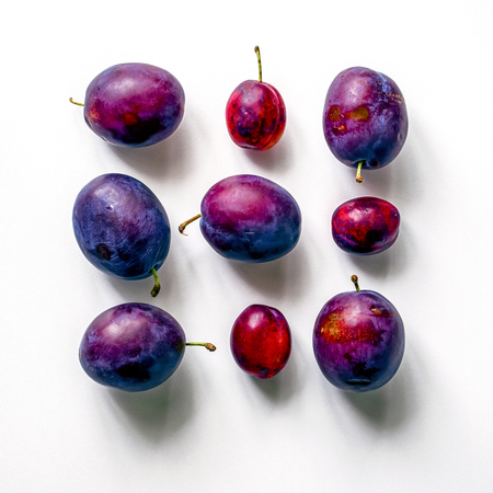 Square of fresh plums.  Food Photo. Creative scheme of whole plums on white background. View from above.の写真素材