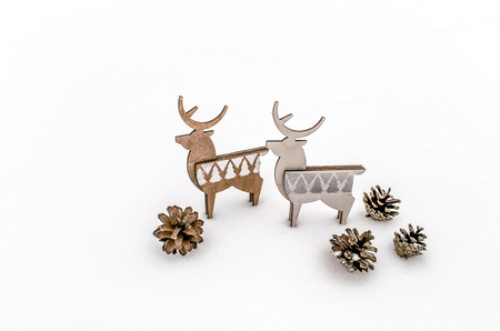 A pair of deer plywood with cones on white snow. Christmas background for presentation of work or text. Copy space.の写真素材