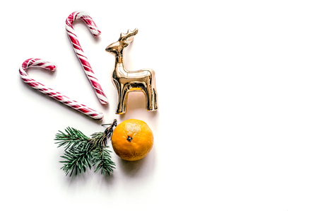 New Year's unusual composition with spruce branches, sweets, tangerine and deer. Christmas background for presentation of work or text. Beautiful greeting card. View from above. Copy spaceの写真素材