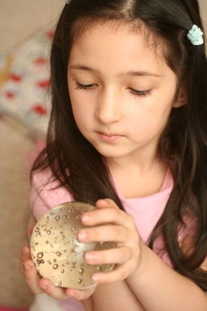 The girl holds a round sphere in handsの写真素材