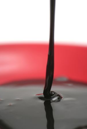 Drops of chocolate on a red plateの写真素材