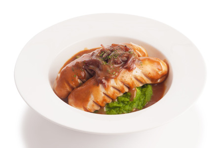 Grilled mixed sausage with gravy and mustard sauce, isolated on white.の写真素材