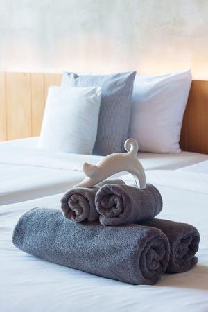 Towels roll on bed in modern hotel room.の写真素材