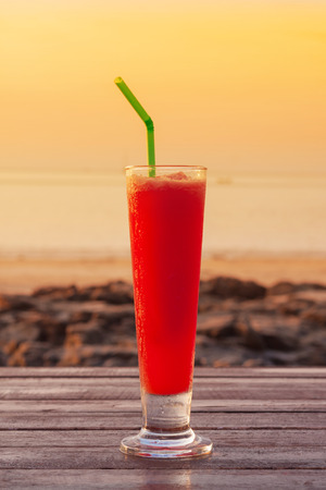 Watermelon smoothie on table with warm sunset sky and sea view of Lanta Island-Krabi-Thailand.の写真素材
