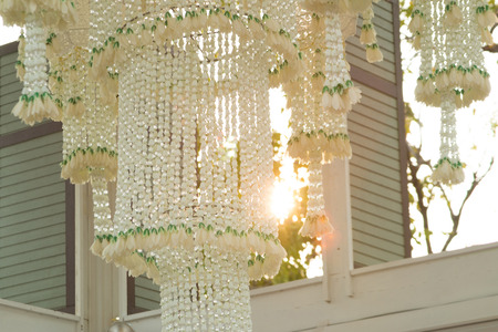 Thai traditional garland chandelier are swaying slowly in the breeze. This picture has footage also.